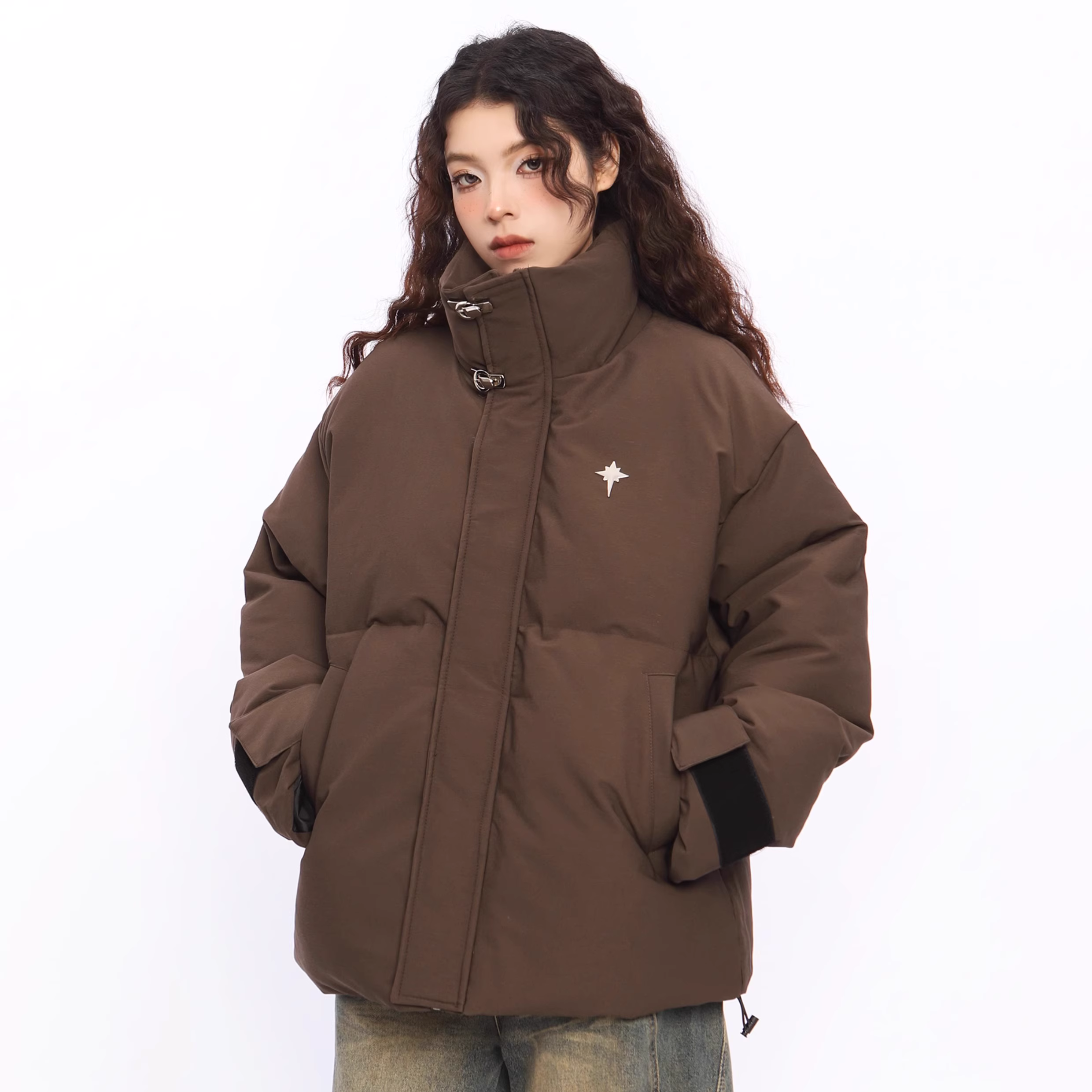 Person wearing a brown puffer jacket with a white logo on a white background