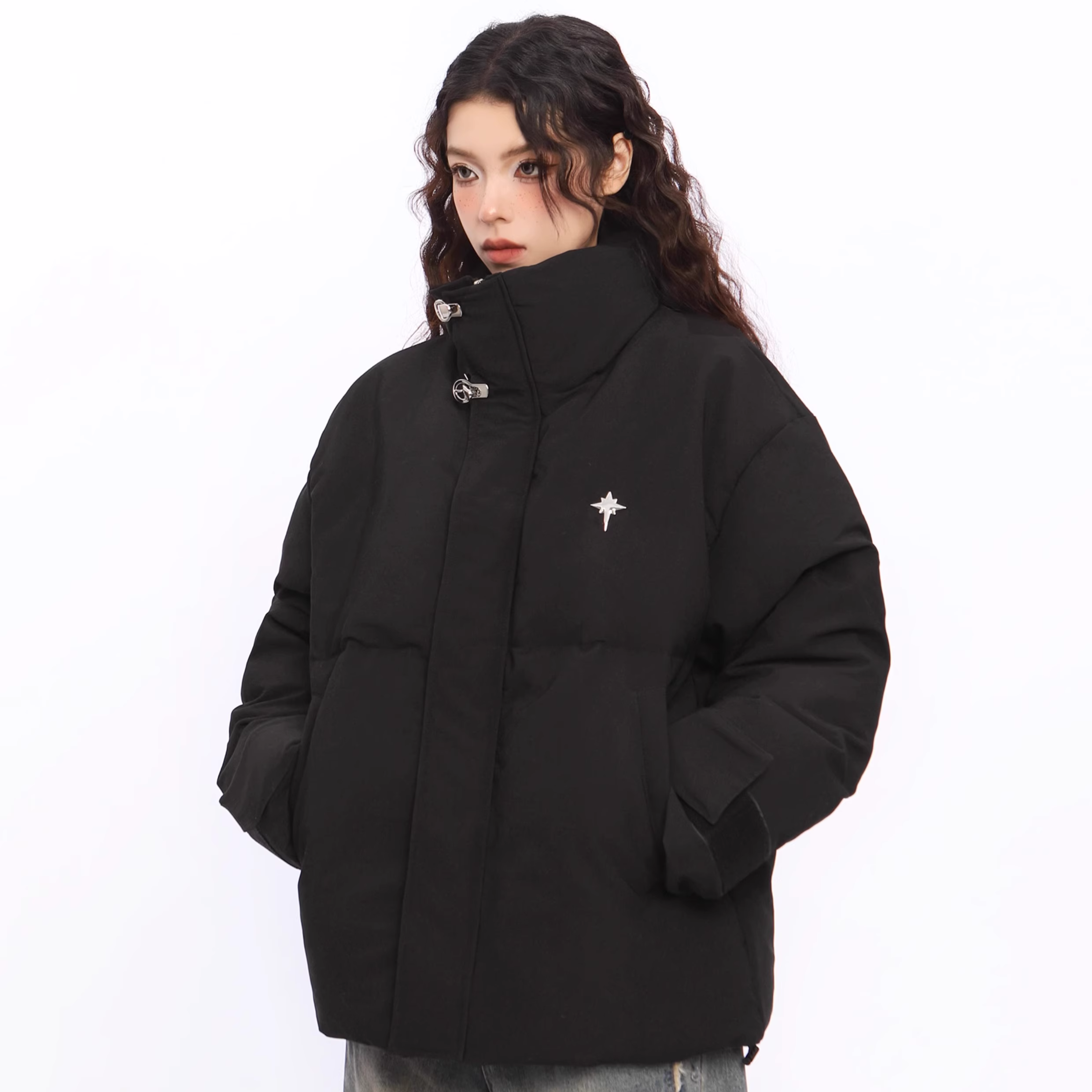 Person wearing a black jacket with a small white logo on a white background