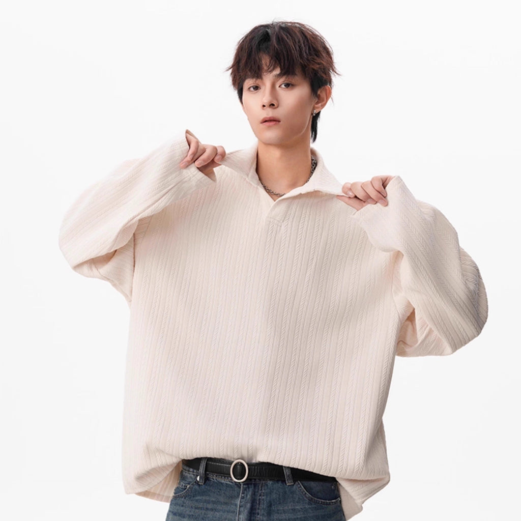 Person wearing a white oversized shirt and blue jeans on a white background